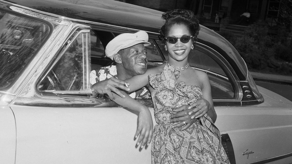 Woman posed against 1952 Lincoln Capri coupe car.