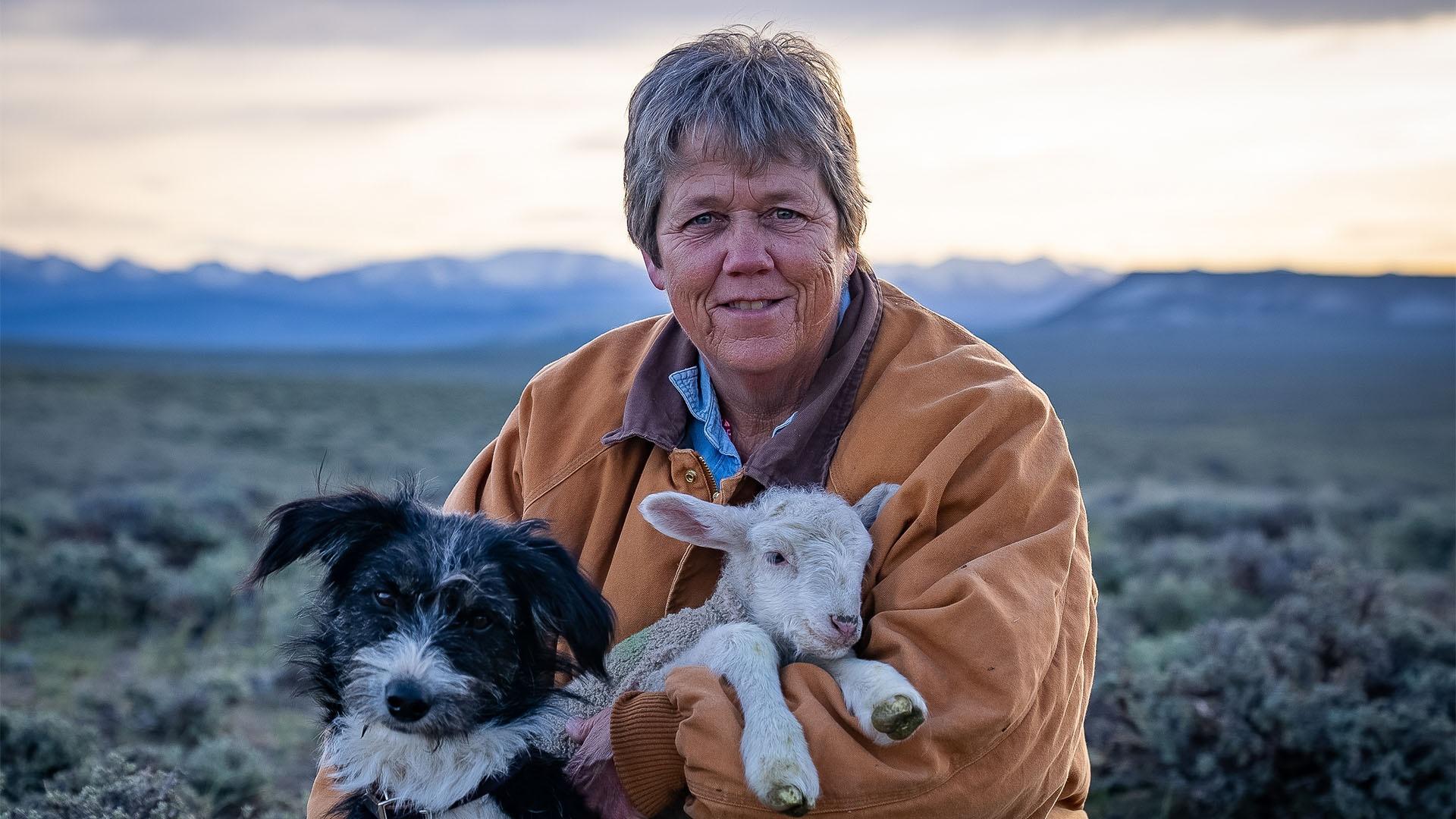 Image of Cat Urbigki sitting with her dog and lamb.