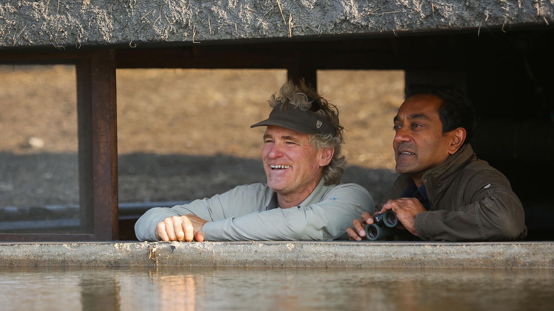 Bob Poole and M. Sanjayan scan the horizon for wildlife from the safety of the hide.