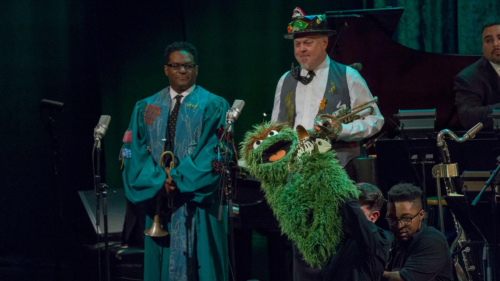 Image of Oscar the Grouch singing "One of These Things" with Marcus Printup and Kenny Rampton.