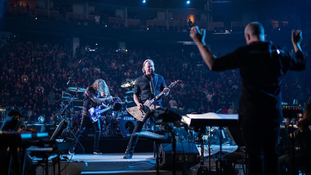 Guitarist James Hetfield and San Francisco Symphony conductor Edwin Outwater performing on stage.