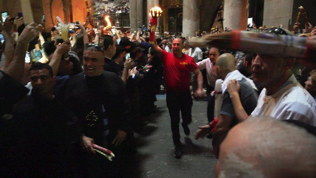 Man running with the Holy Fire in the Church of the Holy Sepulchre, Jerusalem.
