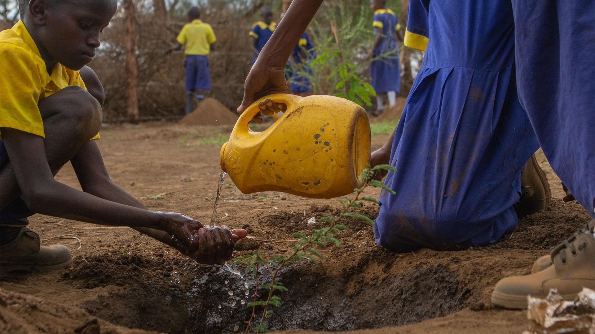 Local child in Kenya planting a tree.