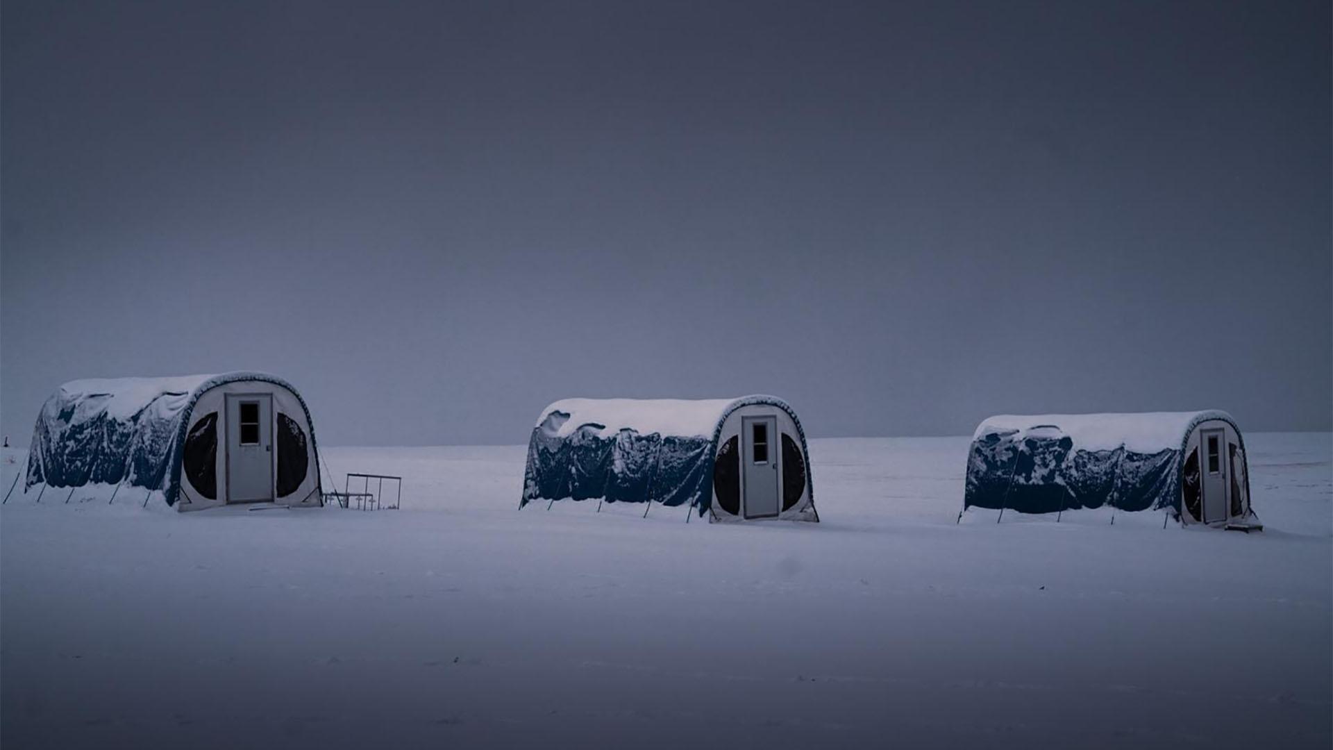 A photograph of snow-covered tents in Greenland.