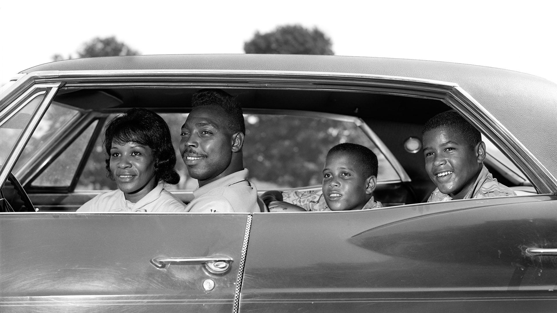 A family in their sedan, 1960s.