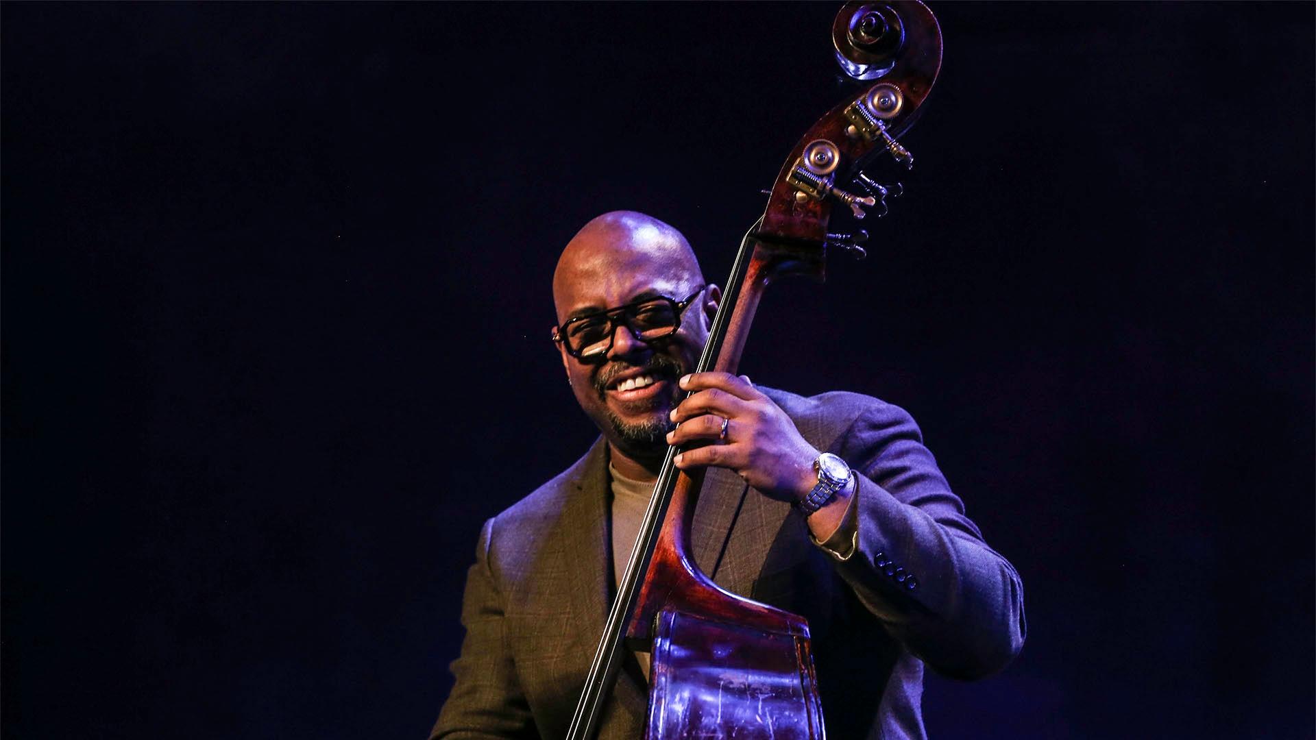 Portrait image of Christian McBride performing with instrument on stage.