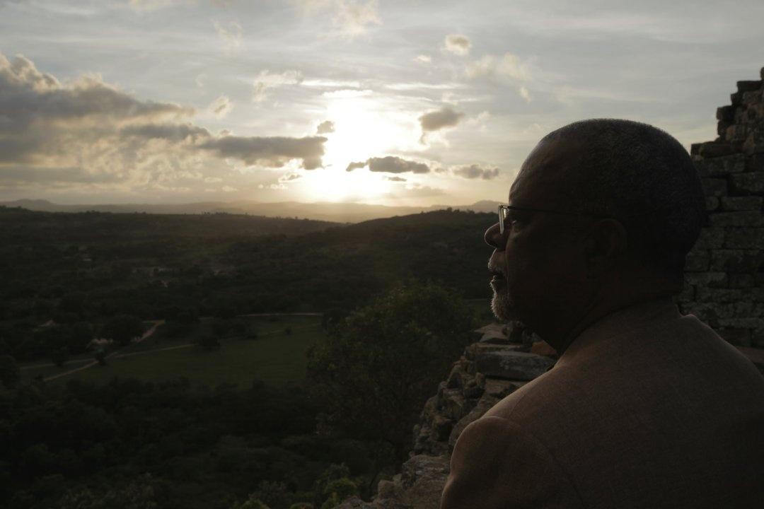 Henry Louis Gates, Jr. gazes out over the valley around Great Zimbabwe, former thriving trade center of the Bantu/Shona people in the Kingdom of Zimbabwe.

