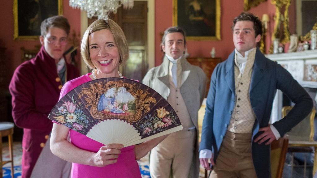 Closeup image of Lucy Worsley standing with suitors from Jane Austen’s “Sense and Sensibility."