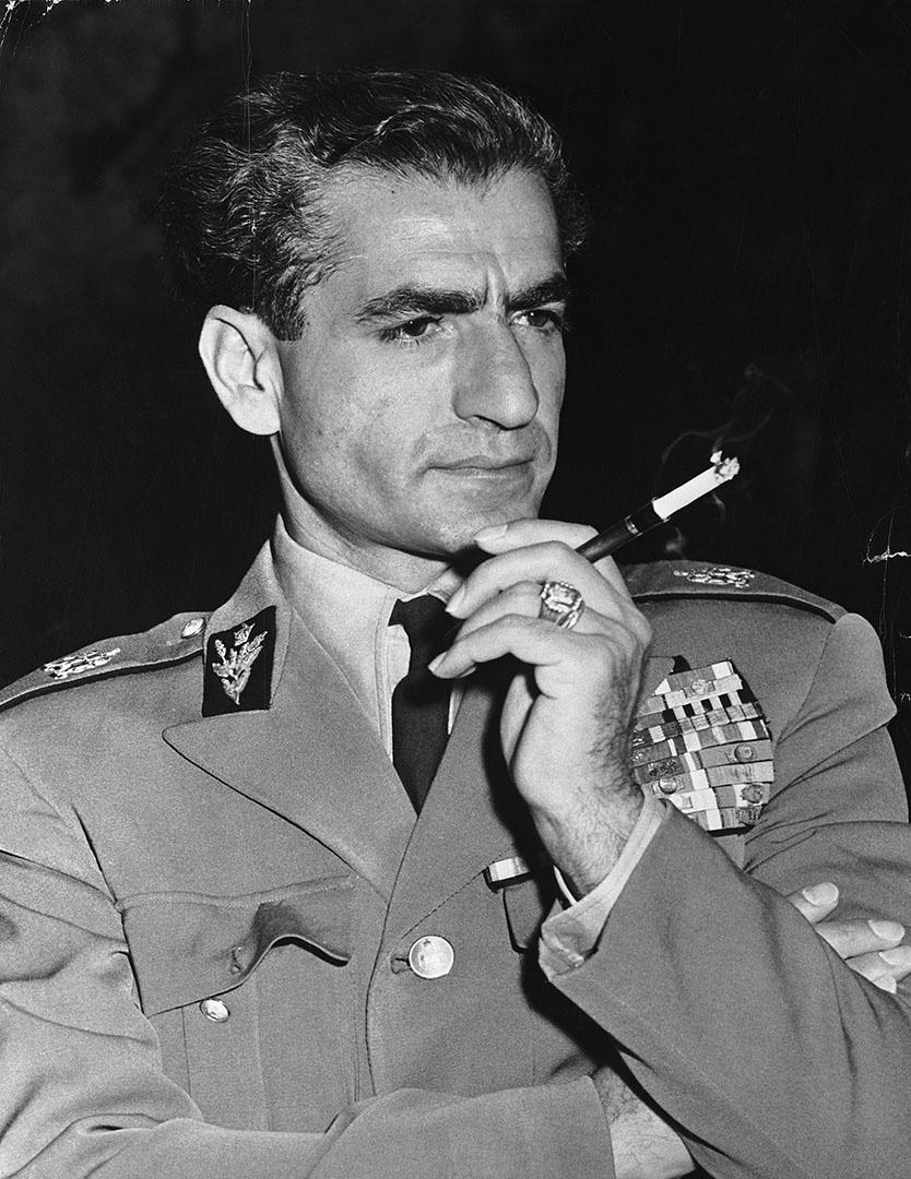 Black and white image of Mohammed Reza Phalevi smoking.