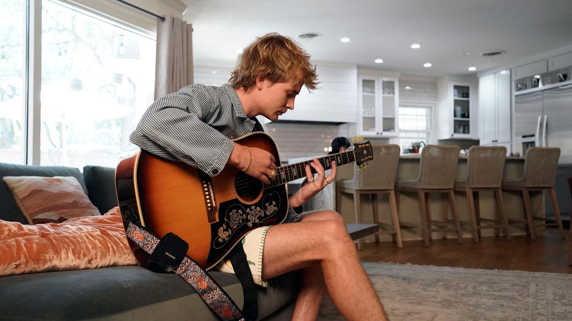 Colin Padalecki from Surfaces plays guitar in his home, as featured on Season 2 of "Texas A&M Today."