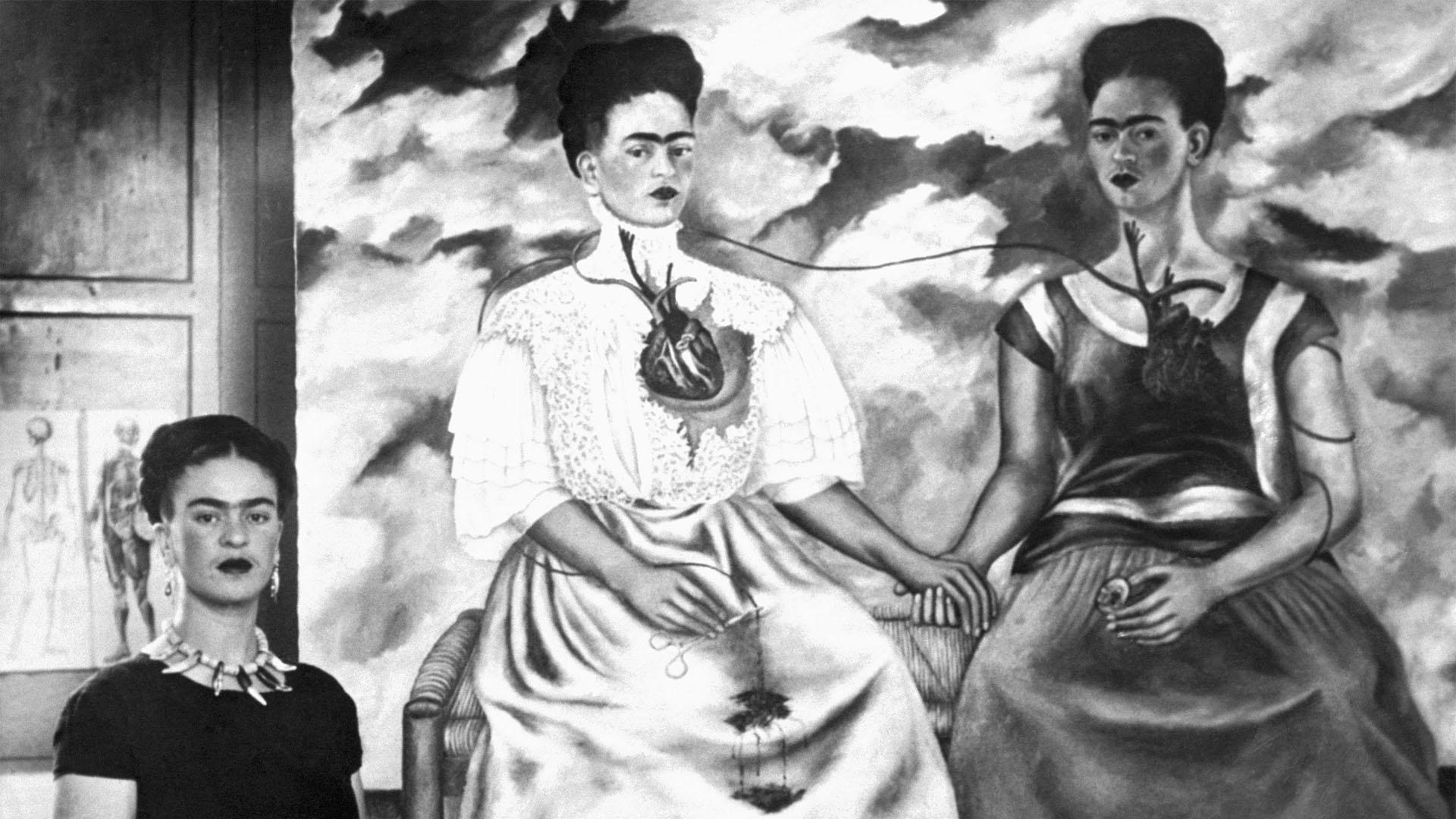 Frida Kahlo pictured with her oil painting “The Two Fridas” in 1939.