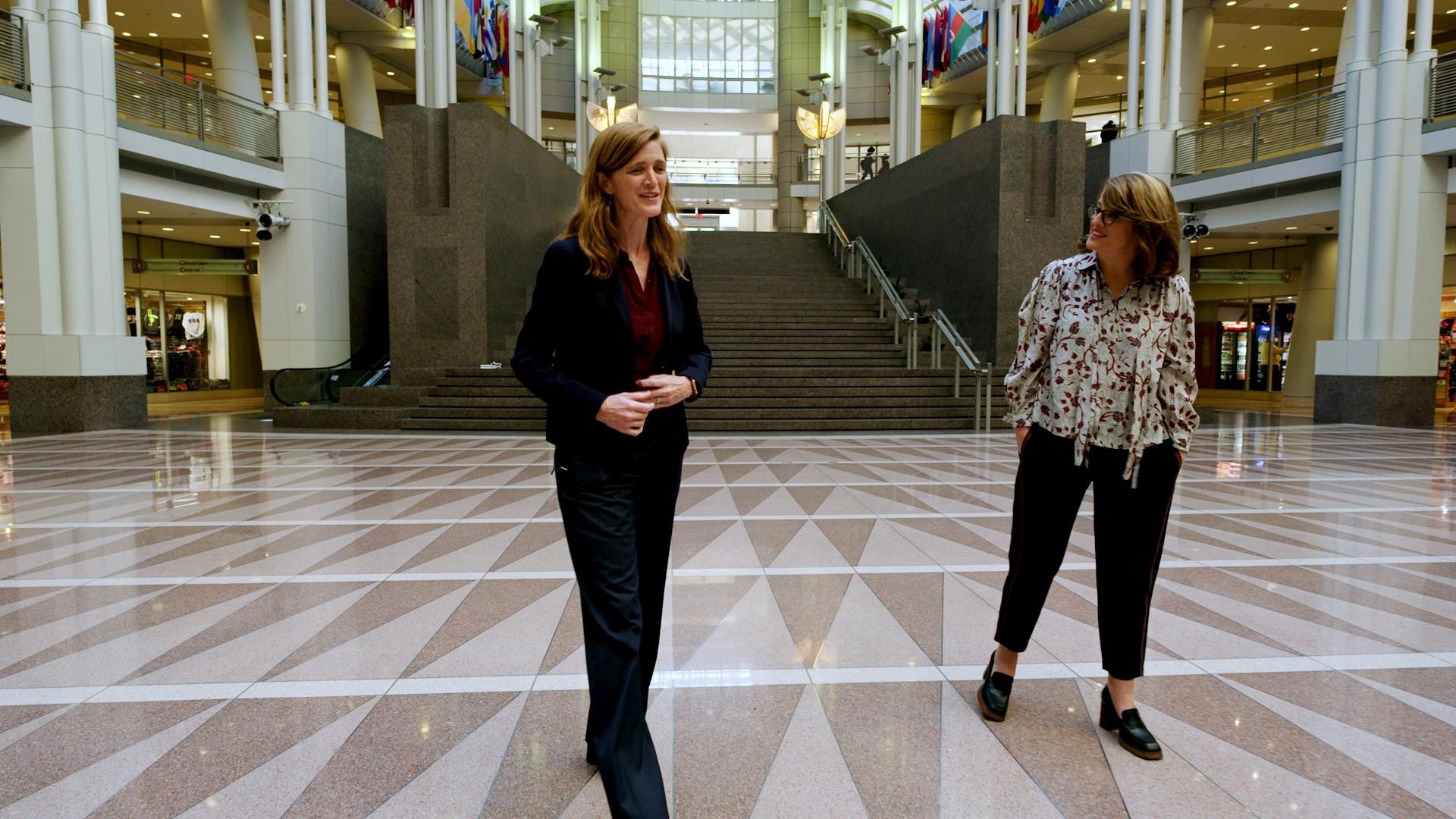 Kelly Corrigan and Samantha Power walk through the Ronald Reagan Building in Washington D.C. 
