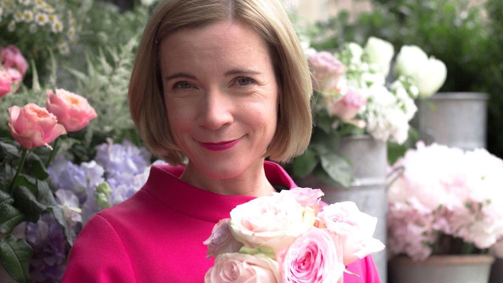 Lucy Worsley holding roses.