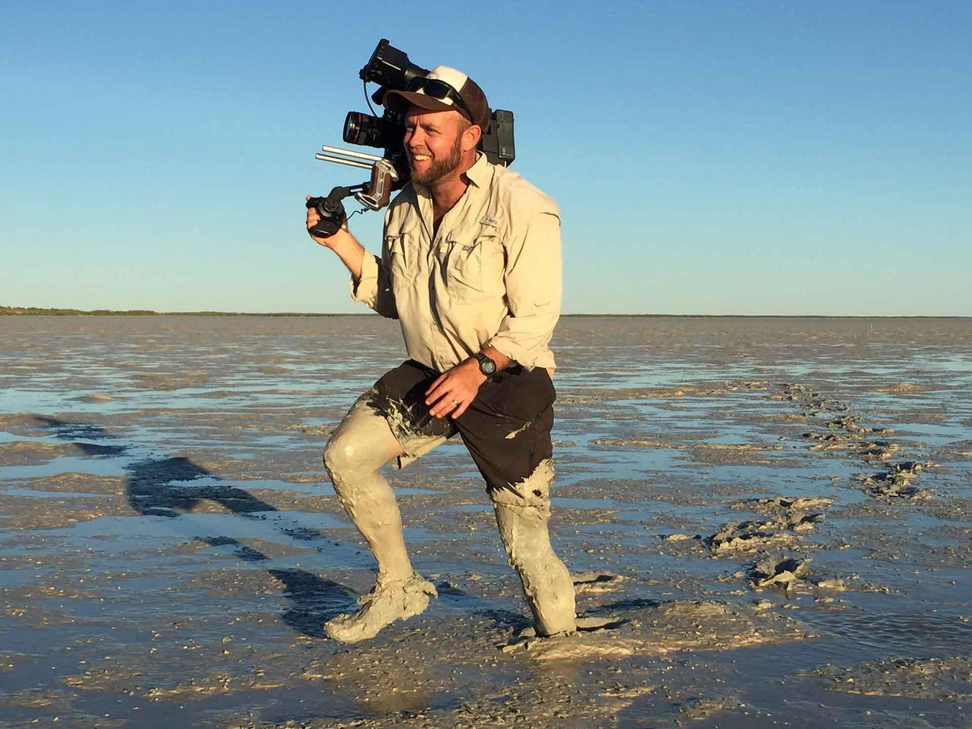 Cameraman, Paul Bell, traipsing through the mud.