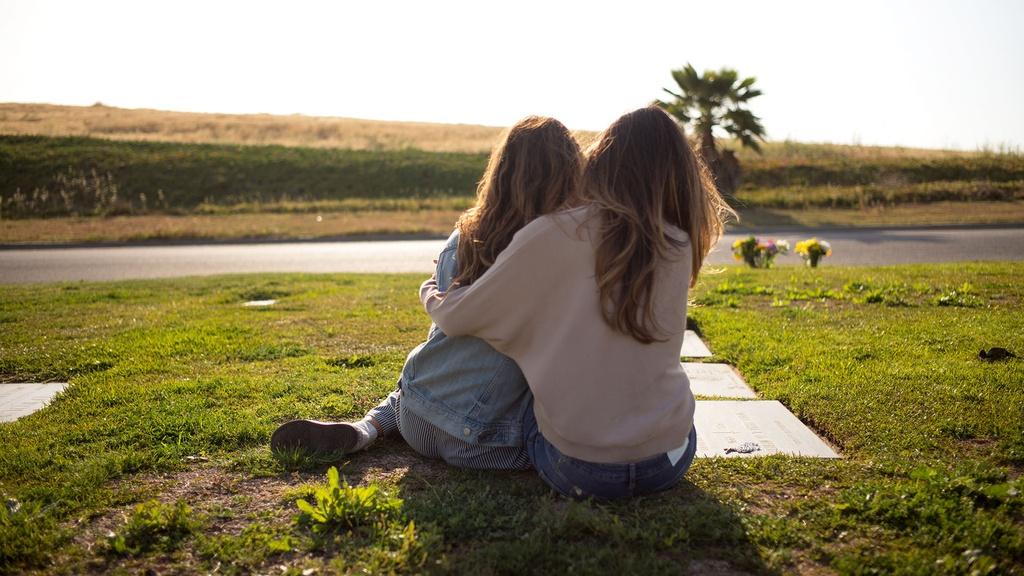 Sisters Alejandra Campoverdi and Monica Medellin at the gravesite of their grandmother.