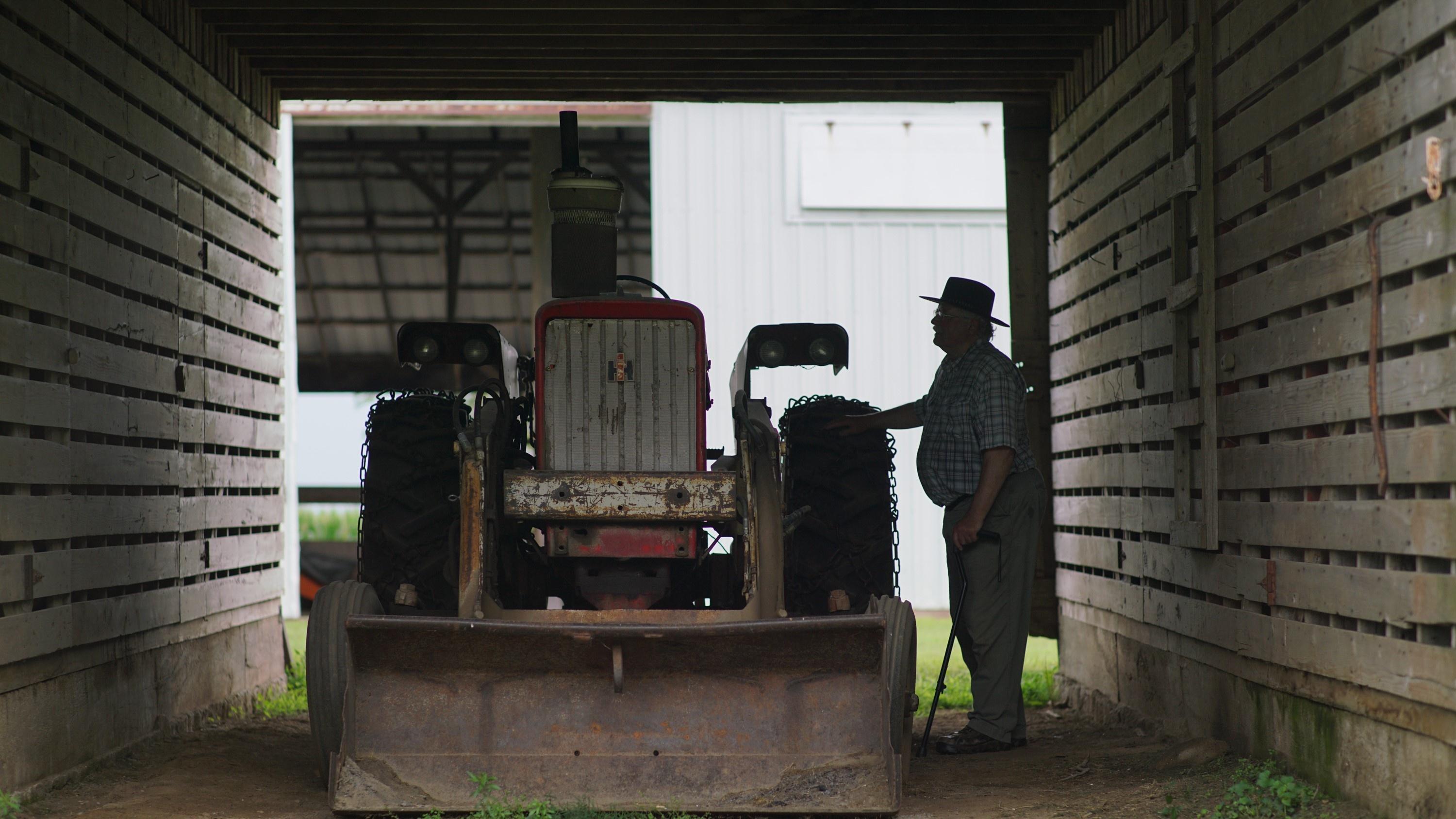Dr. Michael Rosmann, PhD, looks at farm equipment on a farm.