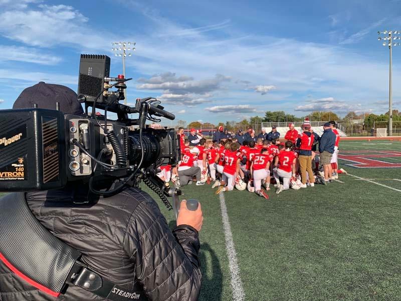 Christopher Ewers (Director of Photography) films a Portsmough High School football game.