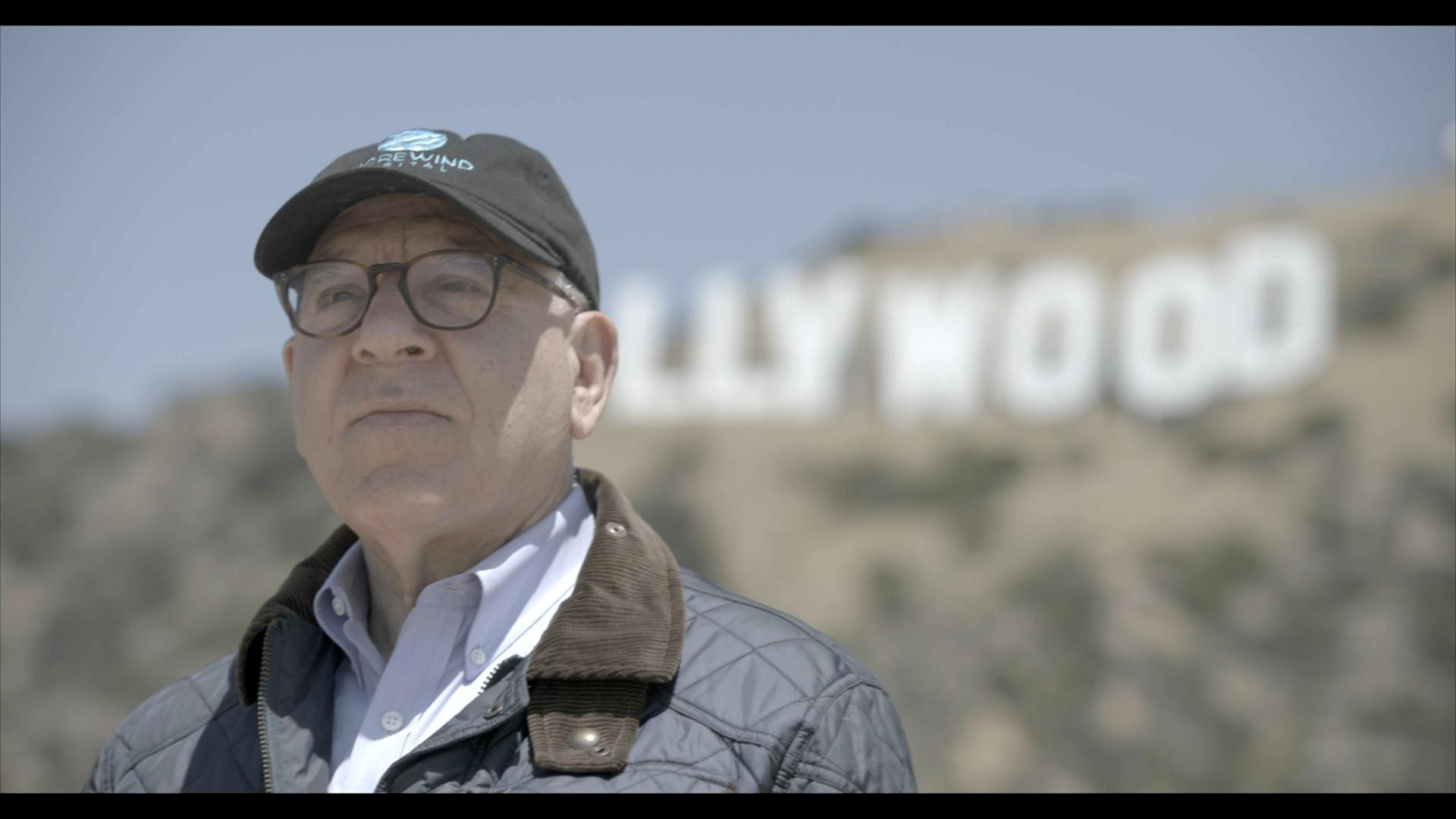 David Rubenstein stands with the Hollywood Sign in the background.