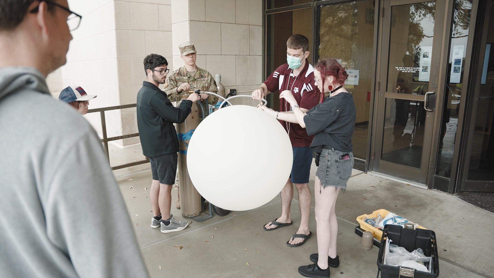 meteorology students prepare to fly a weather balloon
