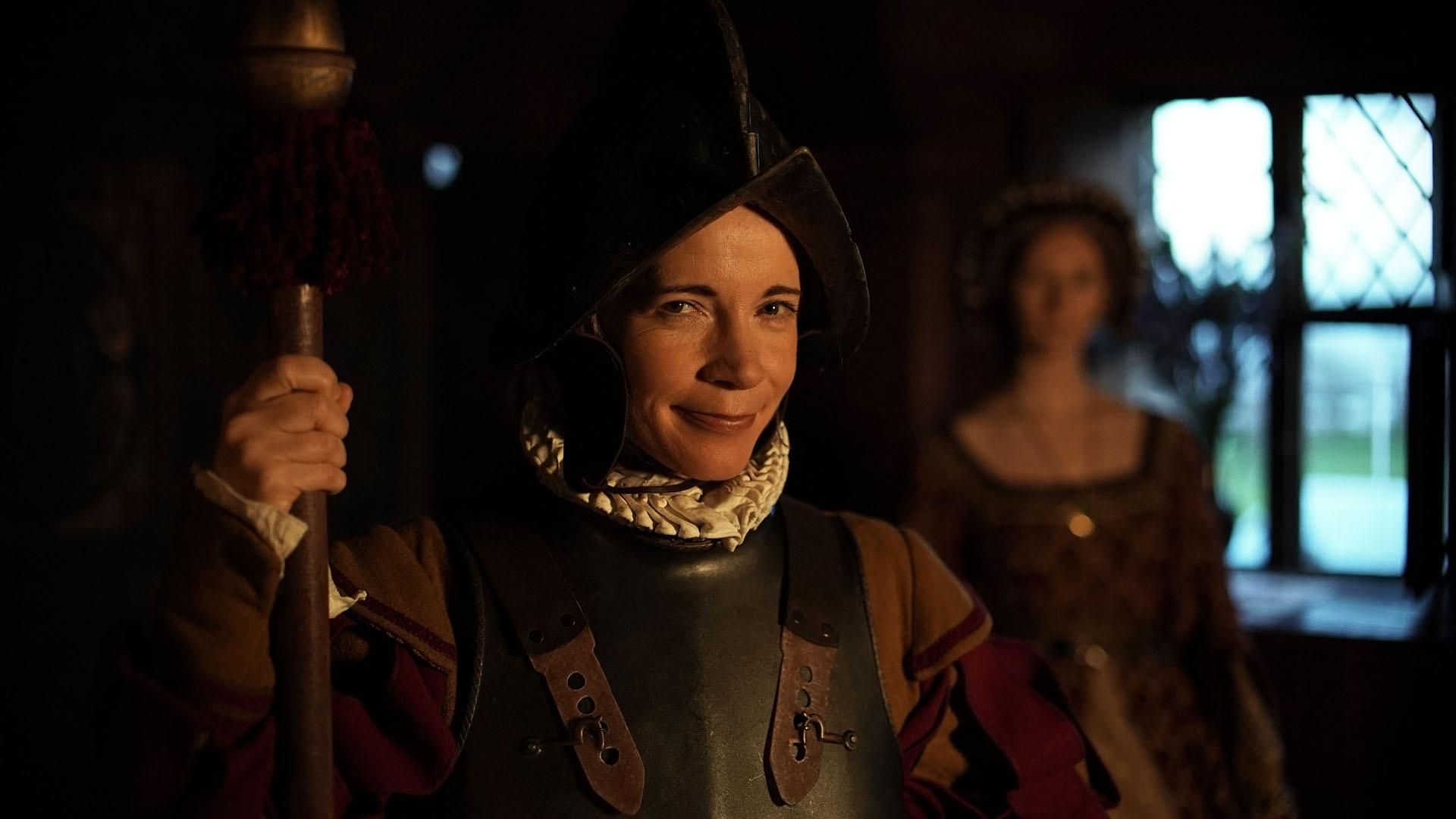 Lucy Worsley dressed as a guard with Anne Boleyn in the background.