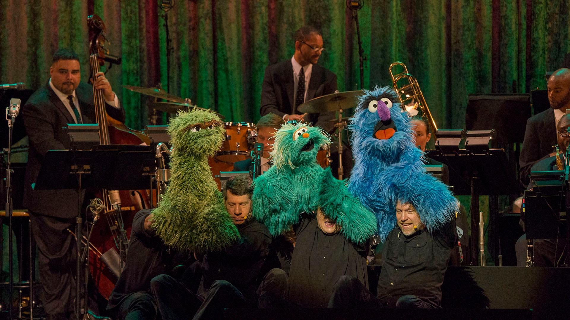 Image of Oscar the Grouch, Rosita, and Herry Monster on stage singing "One of These Things."