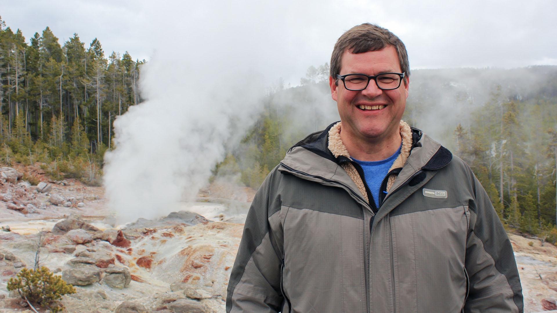 Kirk Johnson in front of geysers.