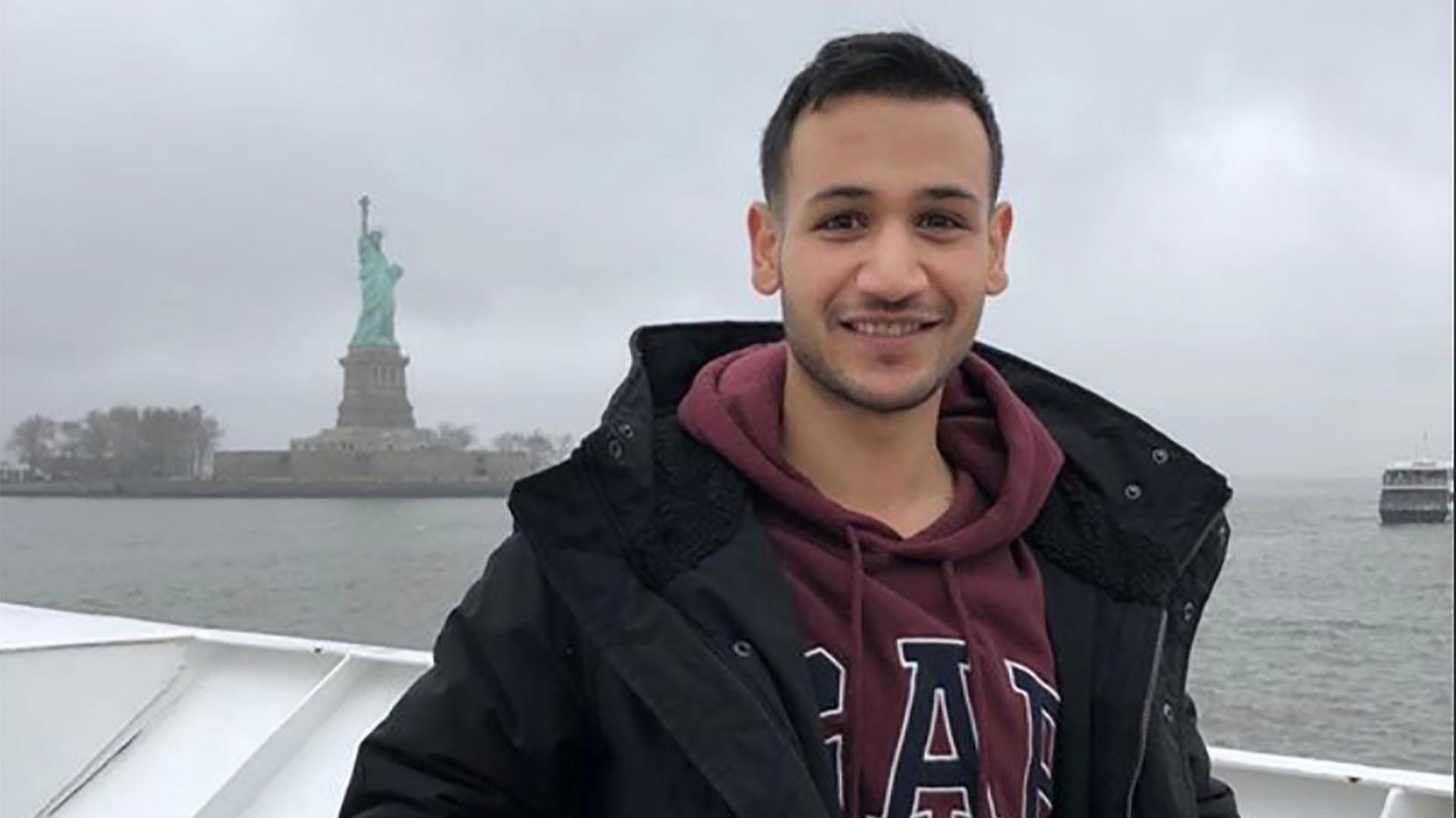 Fares Malahi posing in front of the Statue of Liberty.
