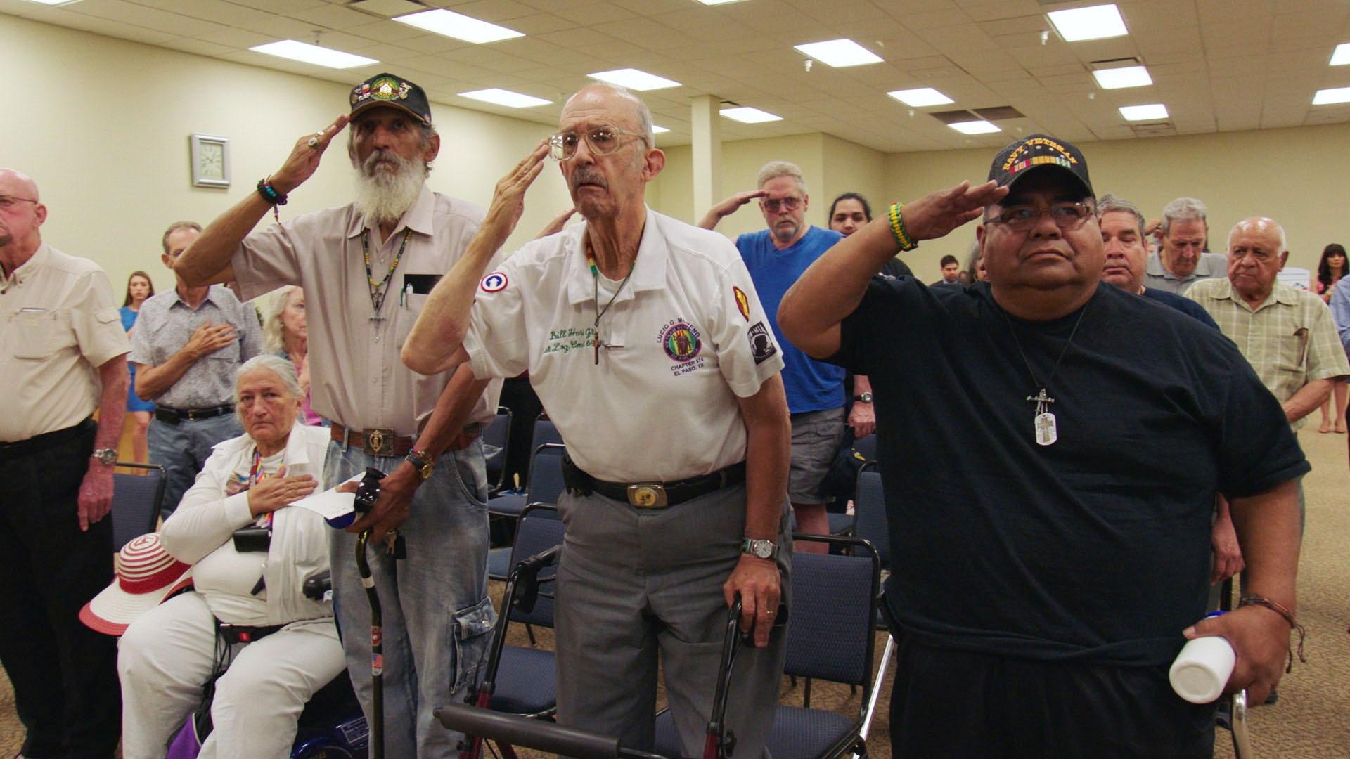 Three veterans salute before a VA town hall meeting in El Paso, Texas.