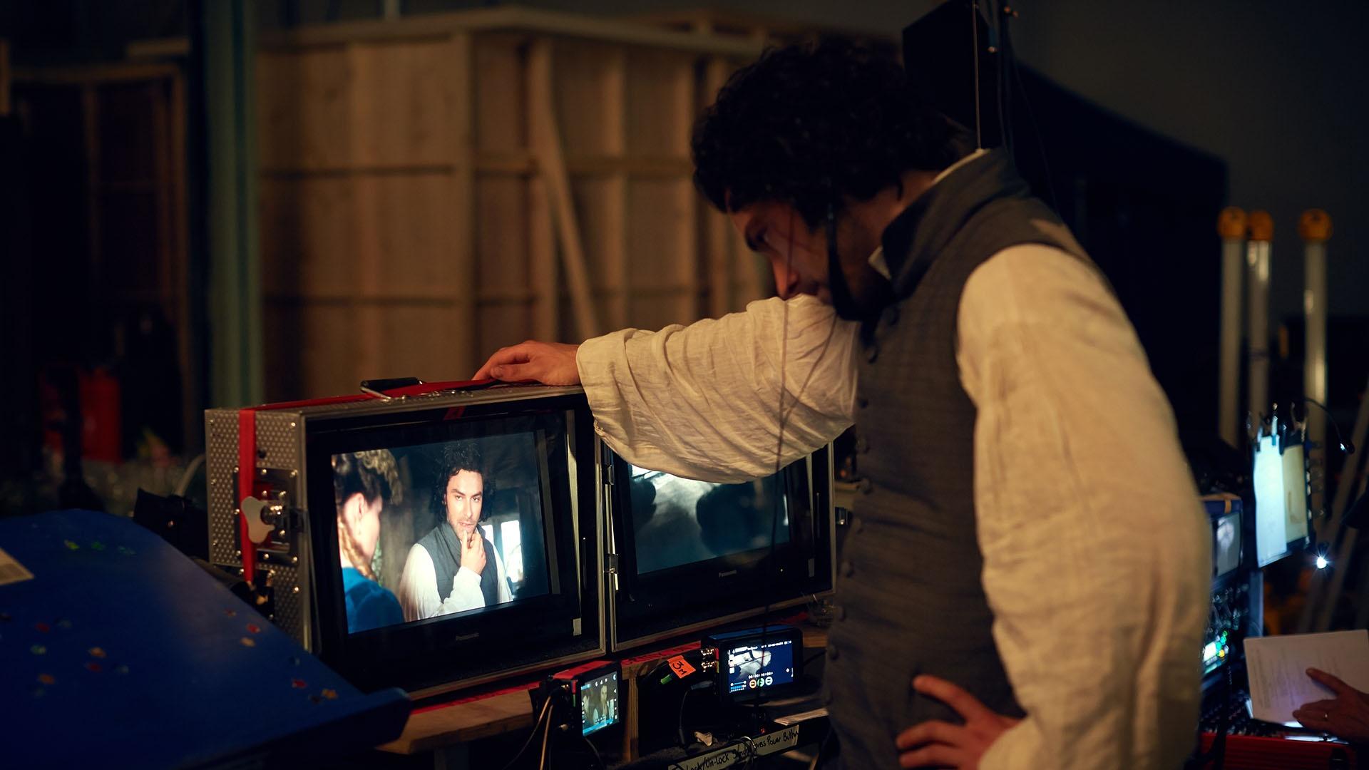 Aidan Turner (Ross Poldark) views his scene in playback on the monitor.