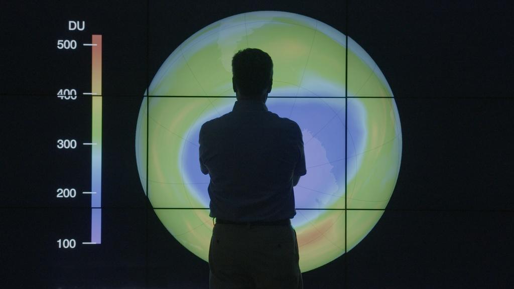 Figure standing in front of ozone graphic.