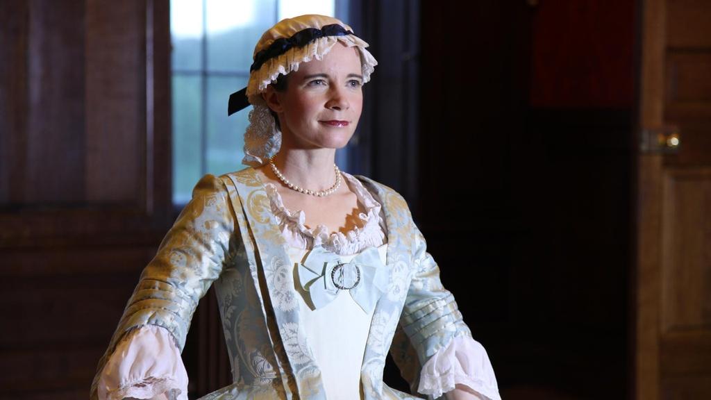 Lucy wearing a replica 1750s light blue mantua-style dress.