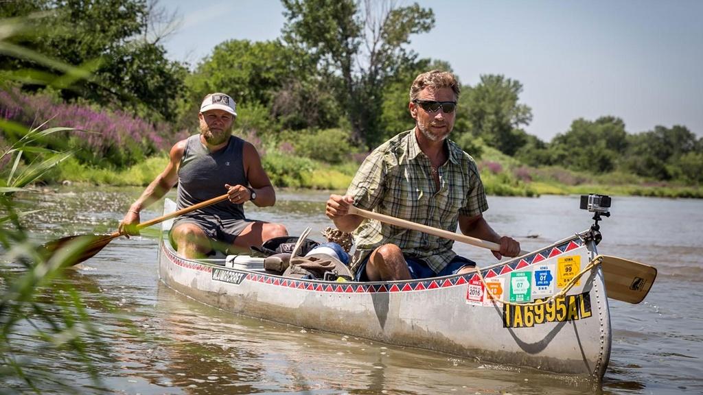 Mike Forsberg and Peter Stegen rowing canoe on river.