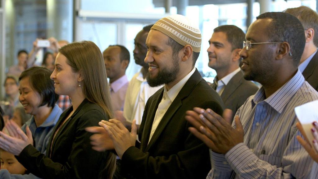 At a naturalization ceremony in Seattle, new American citizens are sworn in by Eric Liu.