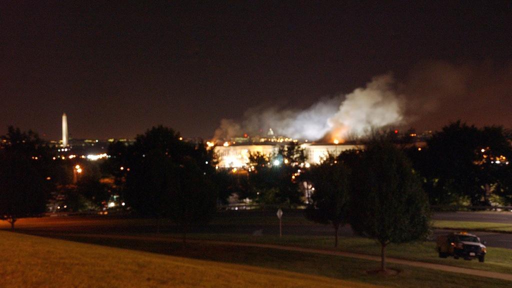 The Pentagon, post-9/11 attack. Flames light up night sky.