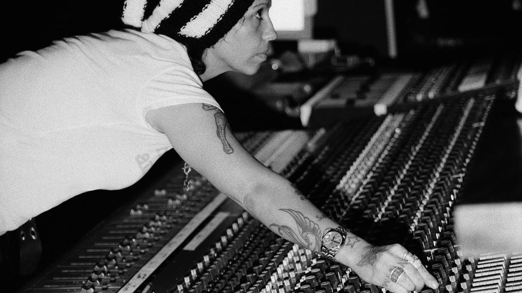 Producer Linda Perry reaches over a mixing board in recording session with Christina Aguilera, 2006