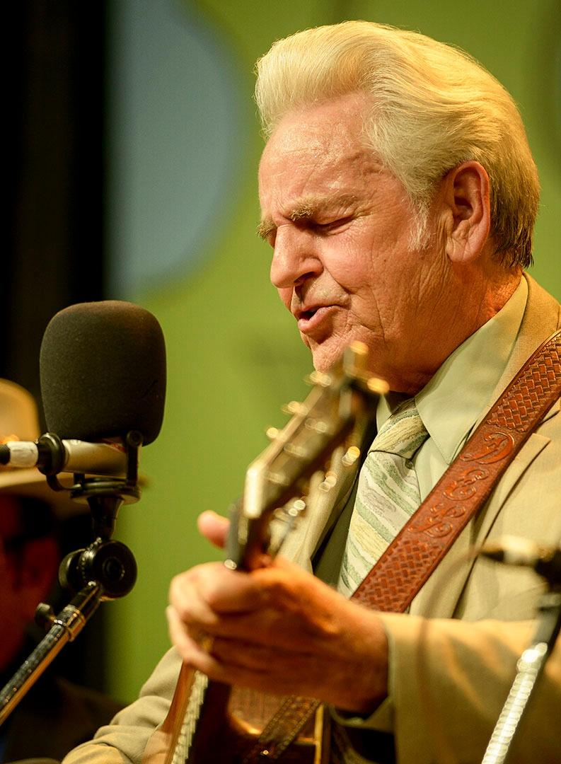 Closeup image of Del McCoury playing instrument