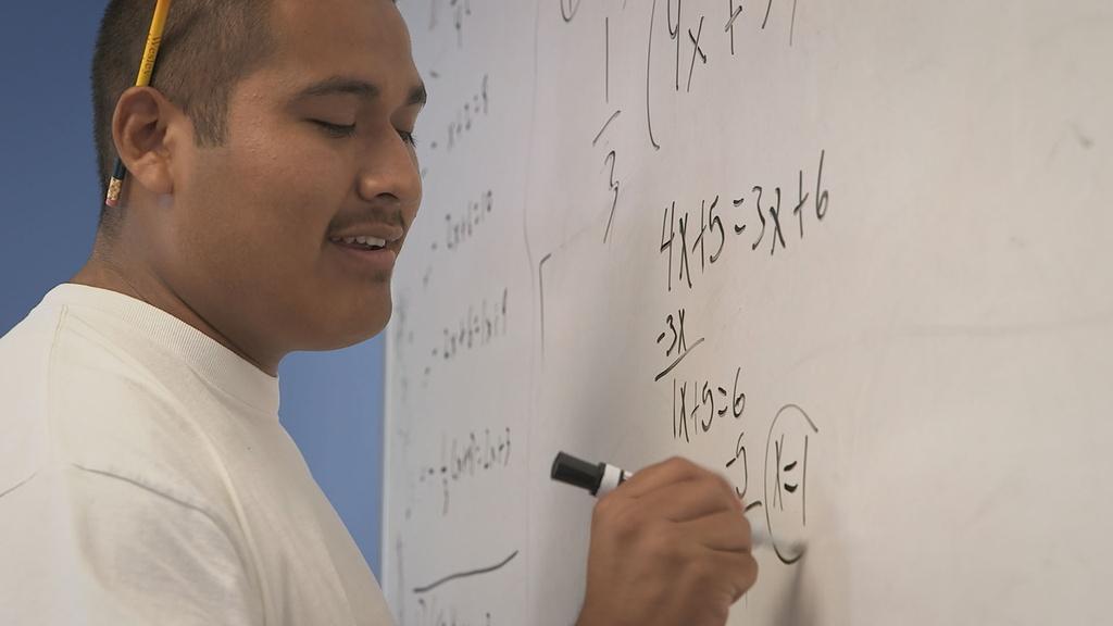 Closeup image of William writing on board