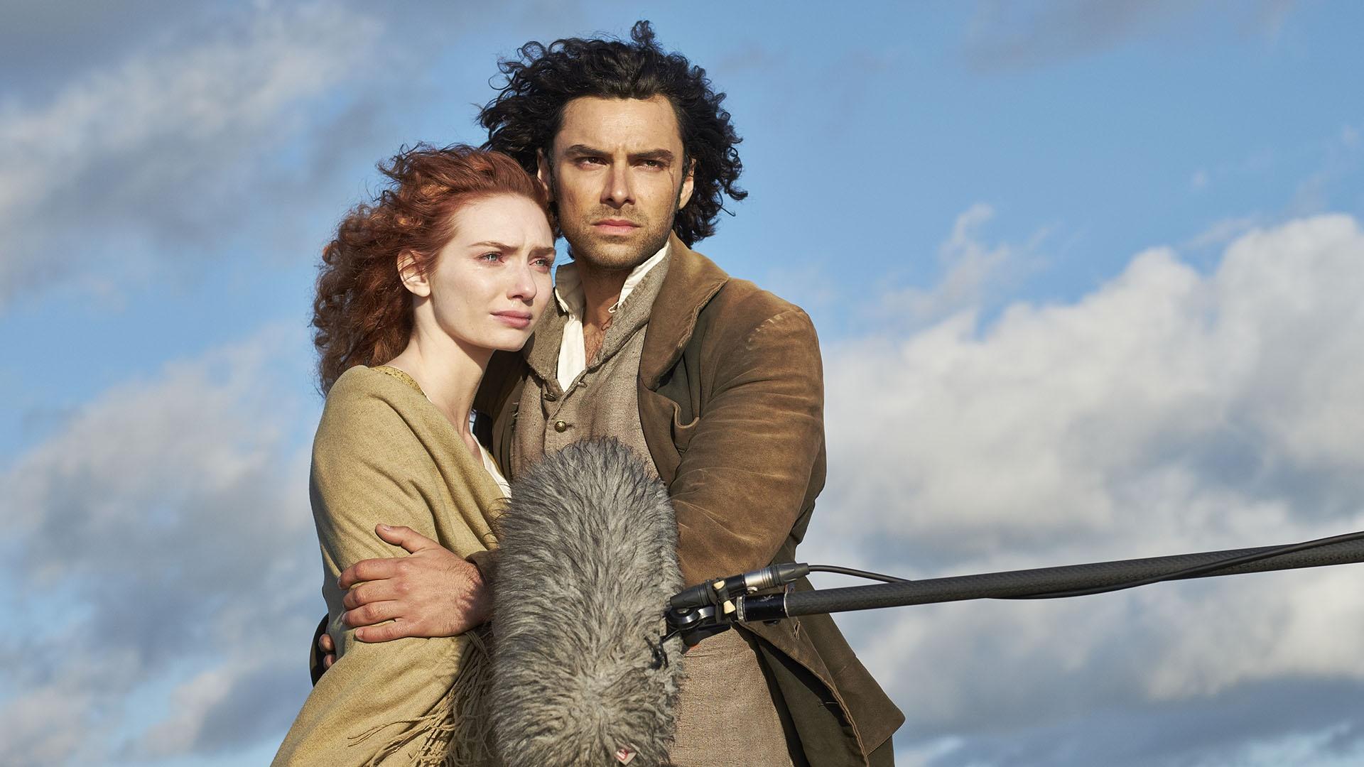 Aidan Turner as Ross Poldark and Eleanor Tomlinson as Damelza in front of a boom mic.