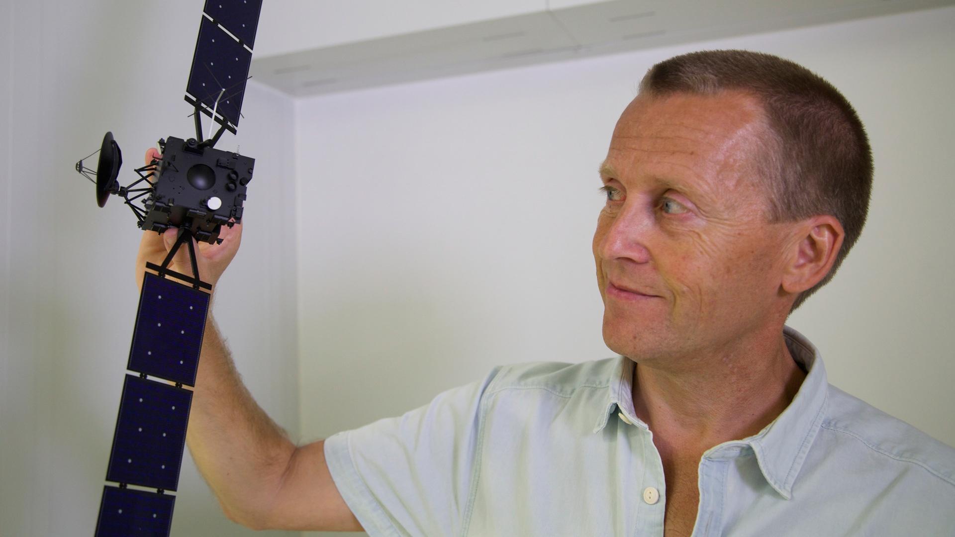 Dr. Holger Sierks holding a model of the Rosetta orbiter