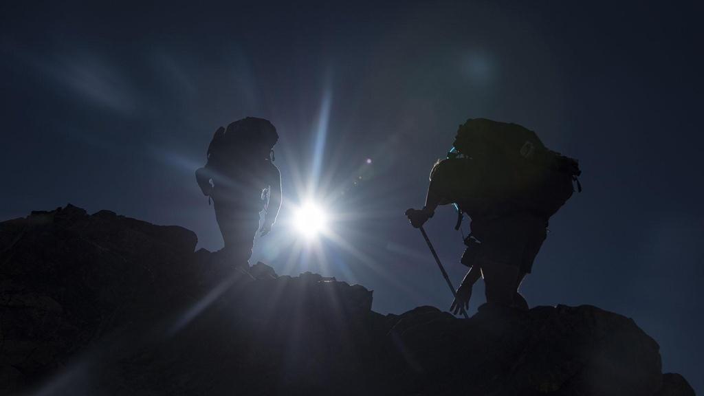 Two hikers climb to the summit of Gray's Peak.