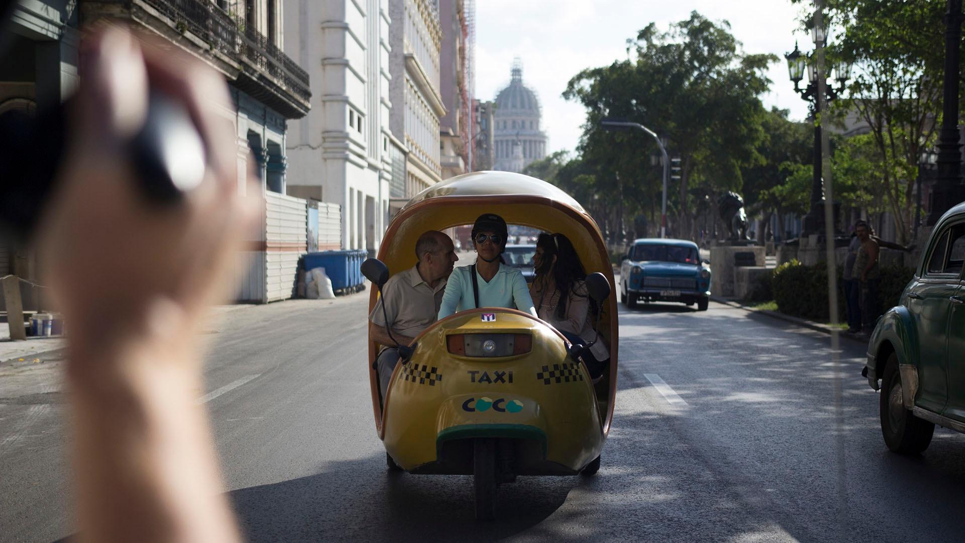 Geoffrey Baer with dancer Irene Rodriguez in a Coco Taxi on Paseo de Prado.