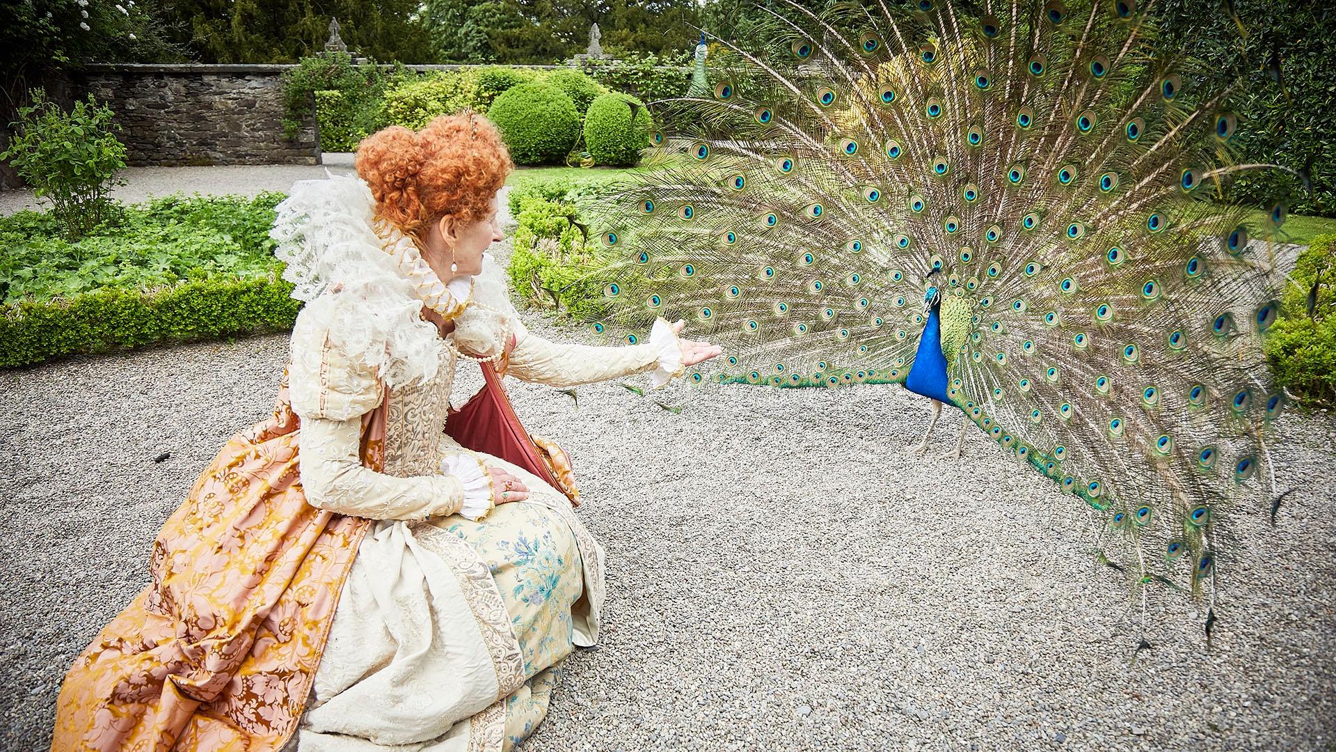Queen Elizabeth I feeding her peacocks.