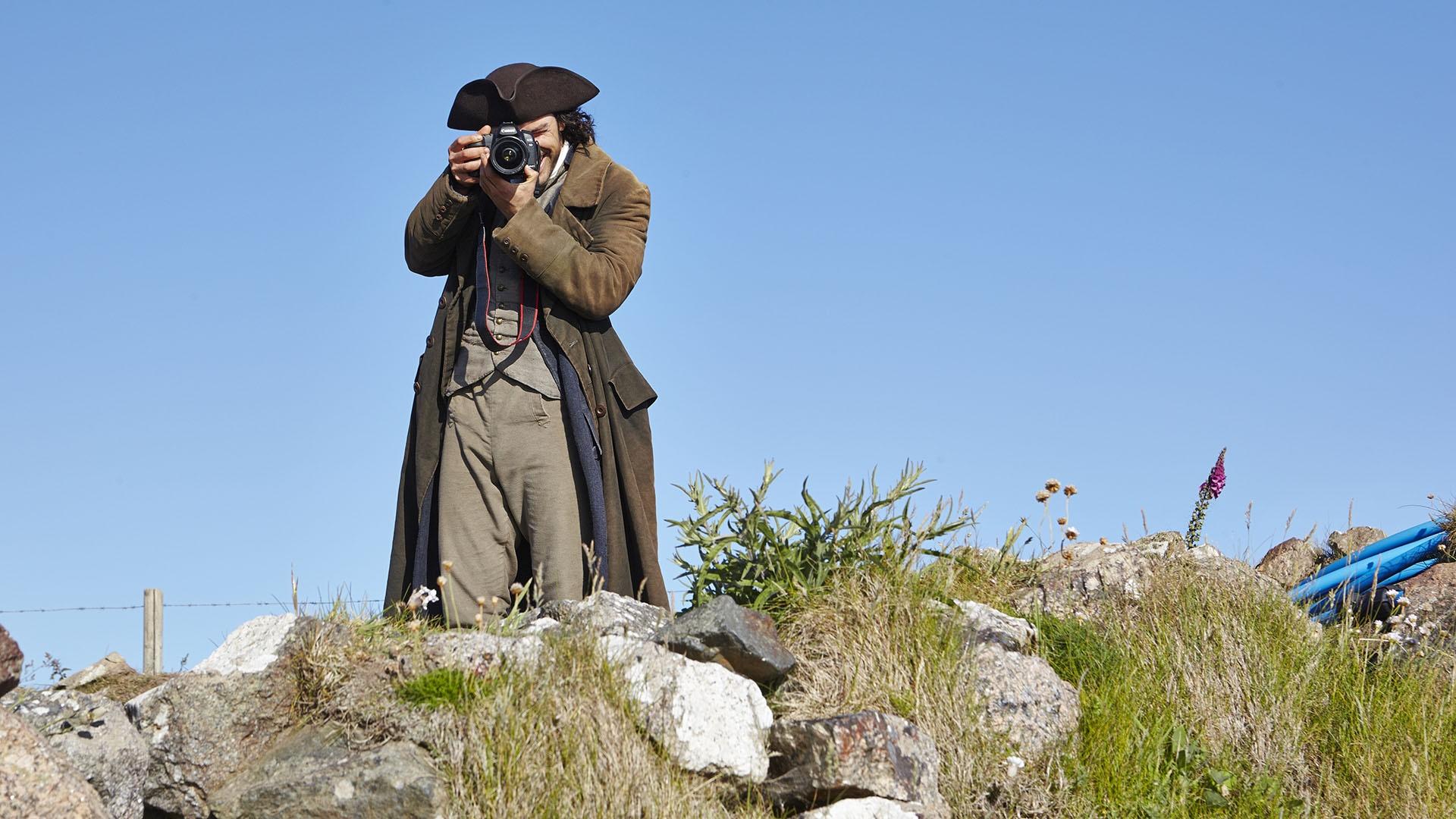 Aidan Turner, in costume as Ross Poldark, takes a photo of the photographer.
