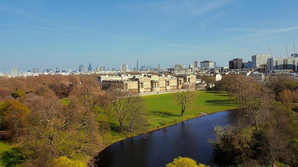 Aerial still of Buckingham Palace with gardens and lake.