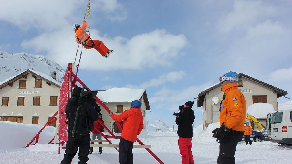 The crew filming the fence being lifted up into the air underneath the helicopter.