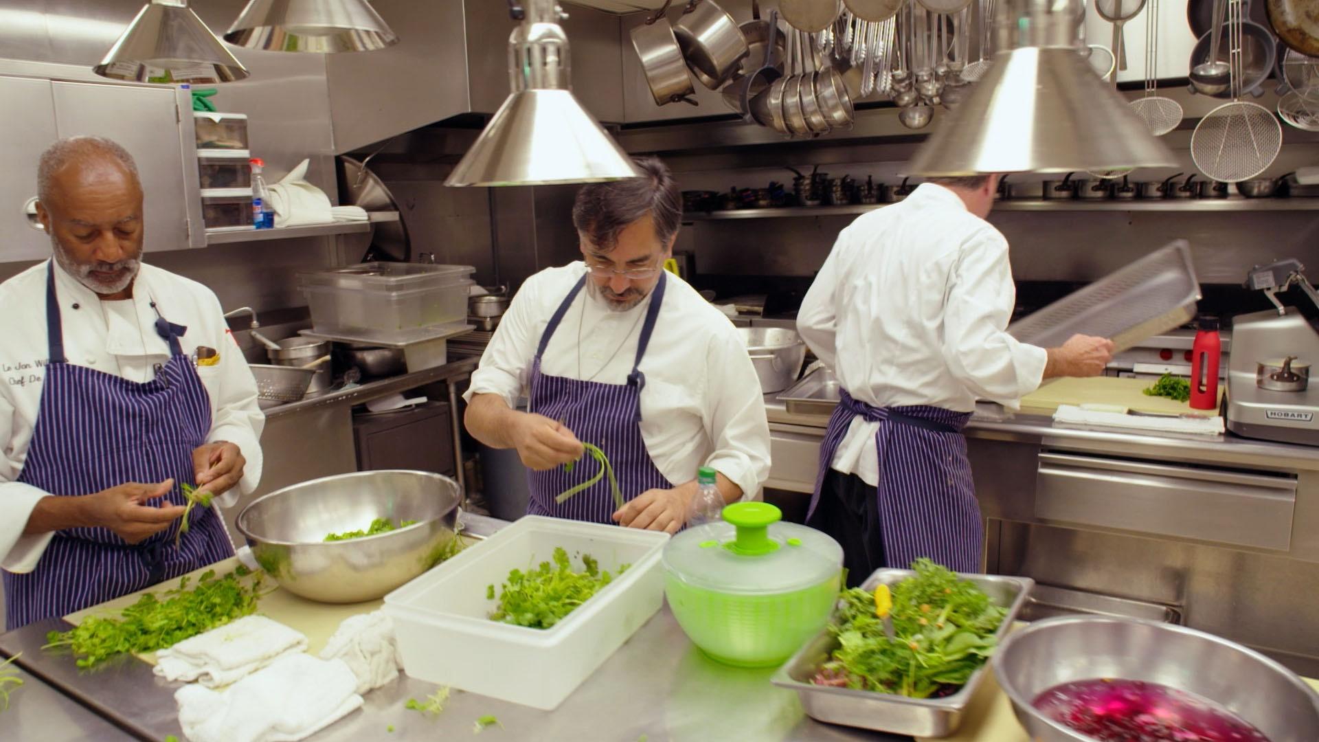 Three White House chefs preparing vegetables.