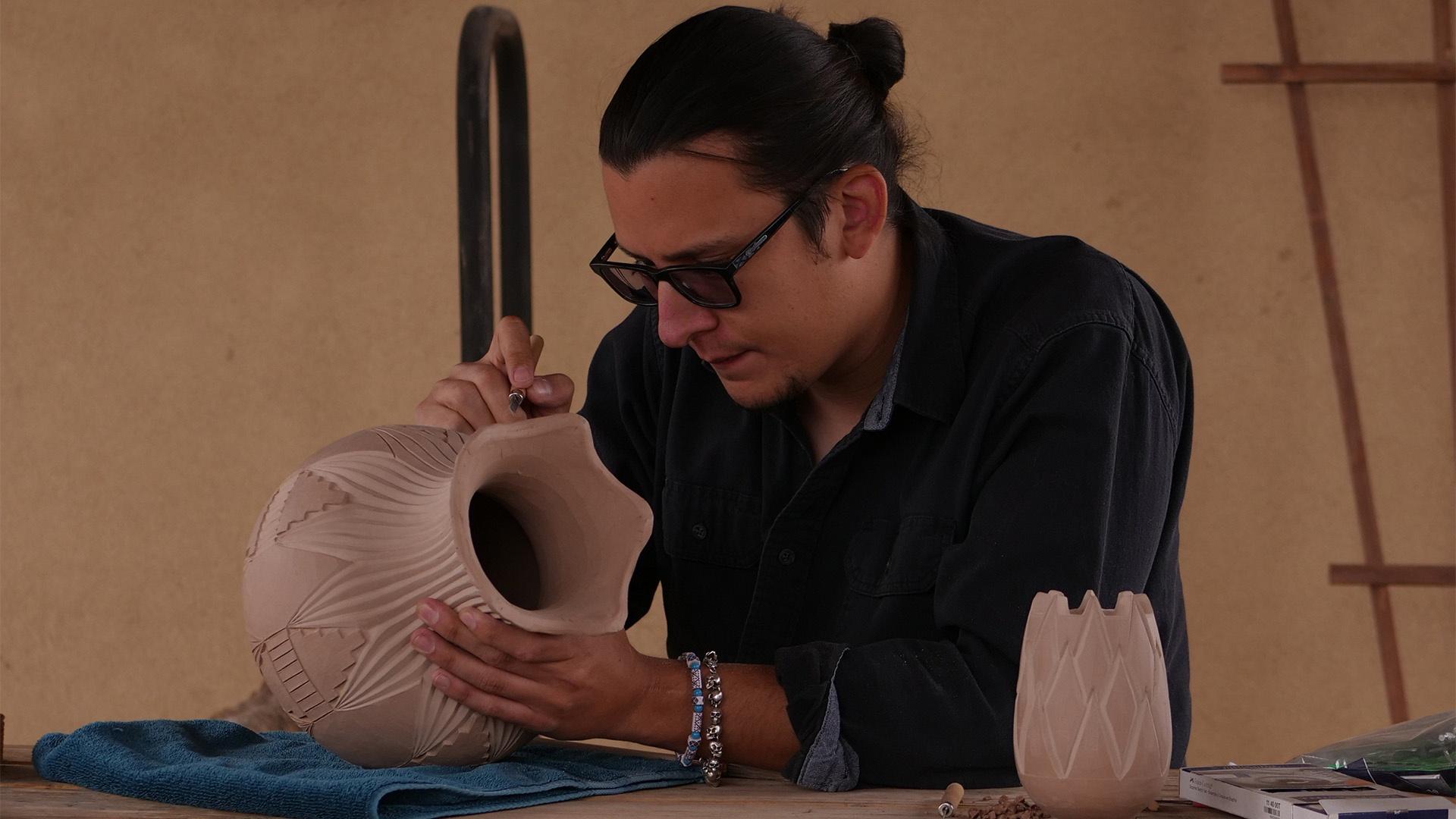 Potter Sergio Youngblood Lugo carves into his pot