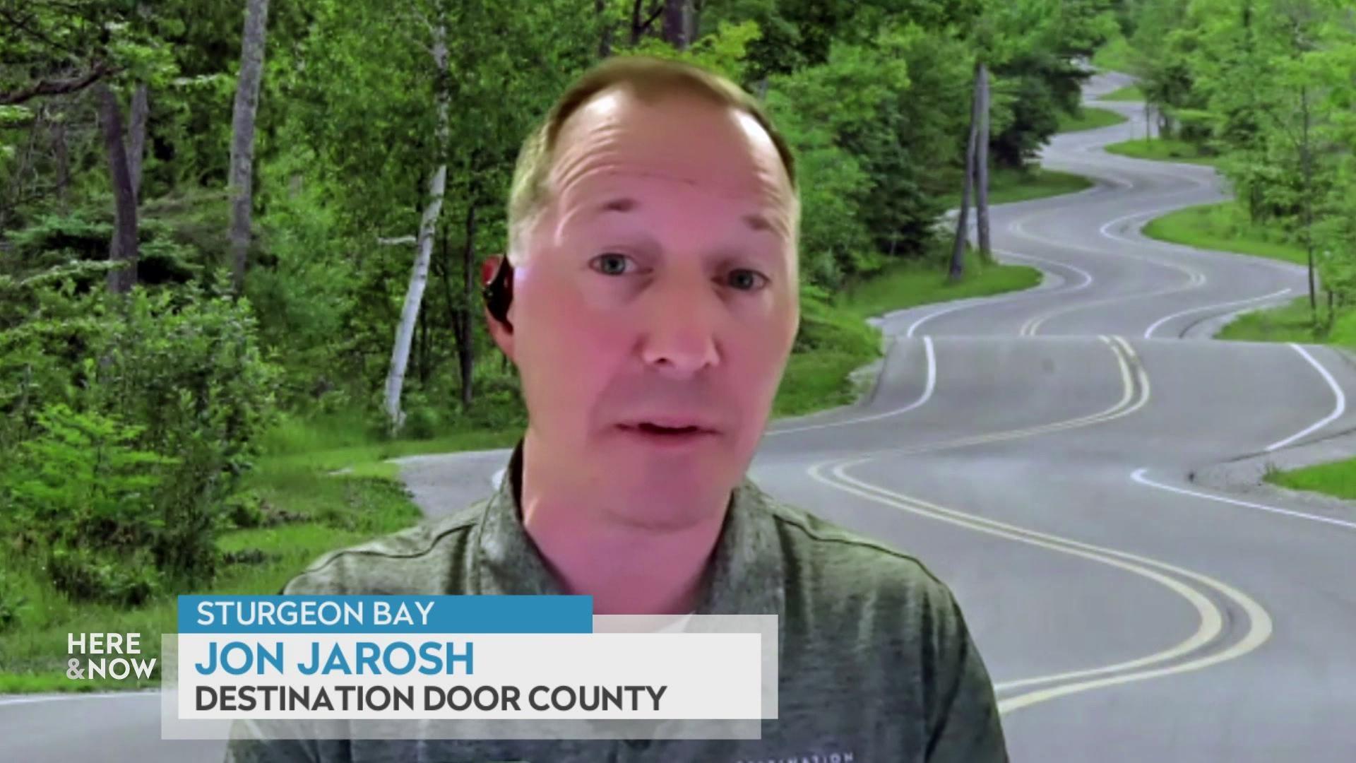 A still image shows Jon Jarosh superimposed on an image of a winding road in a forest, with a graphic at the bottom that reads 'Sturgeon Bay,' 'Jon Jarosh' and 'Destination Door County.'