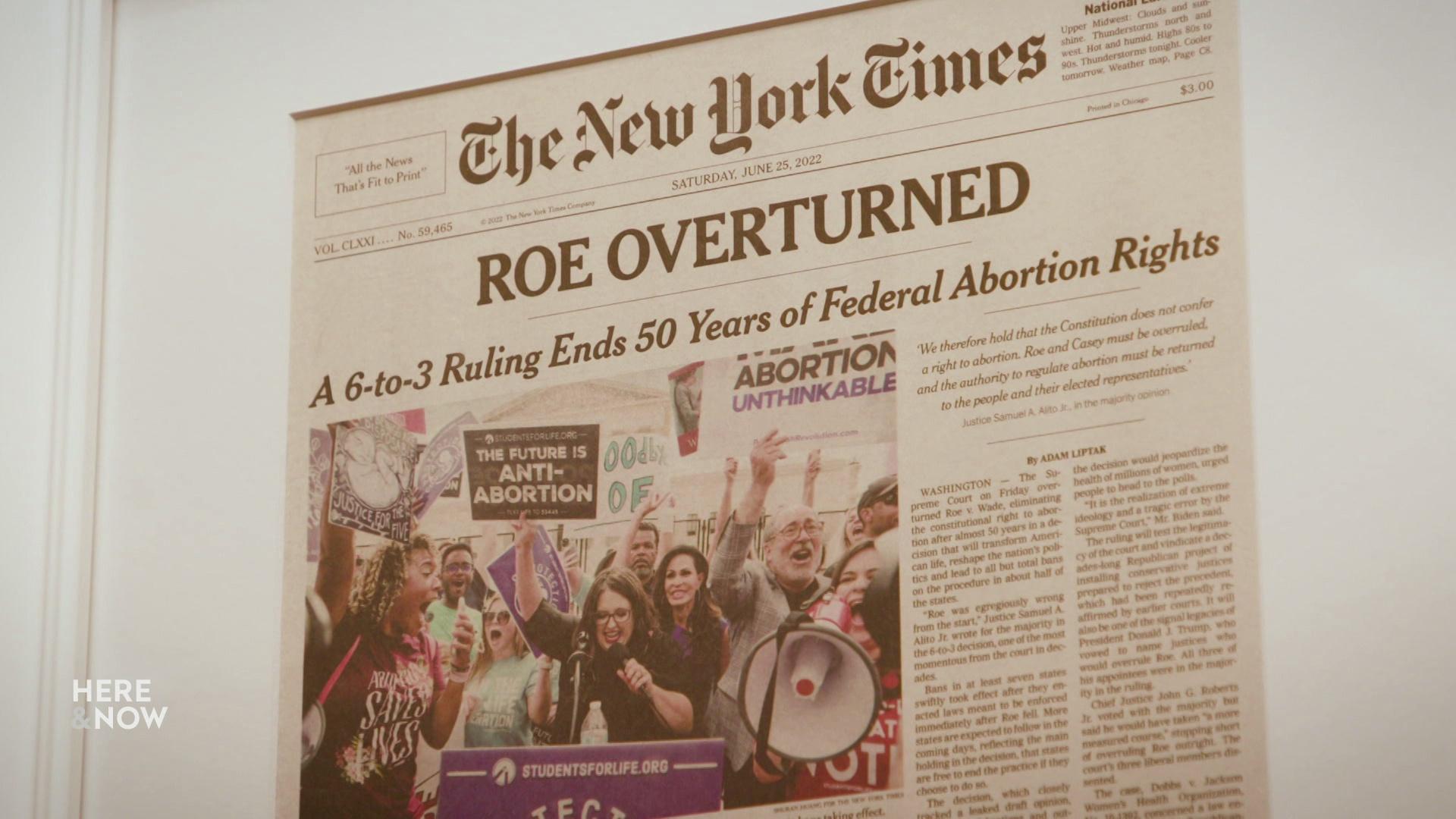 A framed newspaper with a headline from The New York Times reads Roe Overturned, with accompanying photos and text.