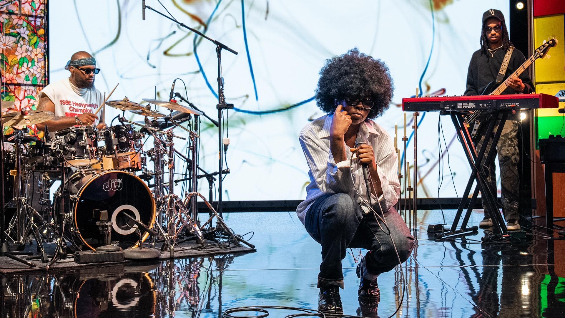 Charlotte R&B musician CYANCA crouching on the set of Shaped by Sound.